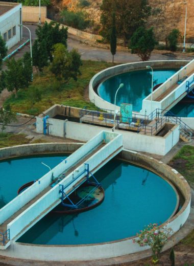 Drone shot of an advanced water purification plant surrounded by trees.